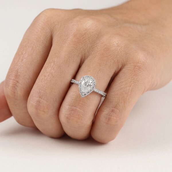 Pear shape diamond ( IGI Certified ) claw set in centre with brilliant cut diamonds claw set in halo and down band.
