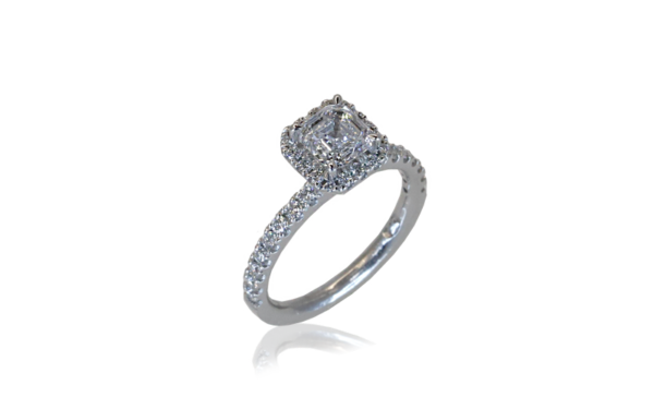 This halo style ring - Delora - features an Asscher cut diamond claw set in centre surrounded by brilliant cut diamonds in the halo and down the band.